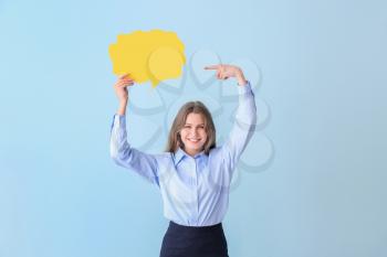 Young businesswoman with blank speech bubble on color background�