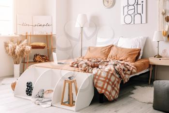 Stylish interior of room with big comfortable bed and autumn decor�