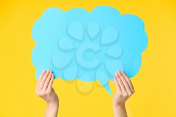 Female hands with blank speech bubble on color background�
