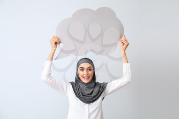 Beautiful Arab woman with blank speech bubble on light background�