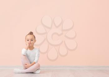 Cute little ballerina against color wall�