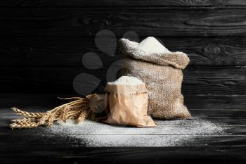 Bags with flour on dark background�