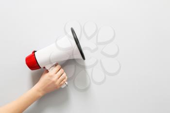 Female hand with megaphone on white background�