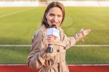 Beautiful reporter with microphone at the stadium�