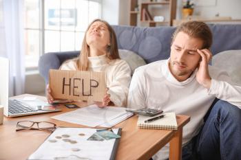 Worried young couple in debt at home�