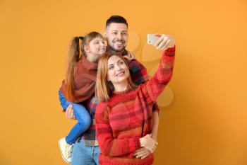 Family taking selfie on color background�