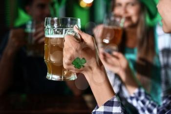 Young woman with friends celebrating St. Patrick's Day in pub�