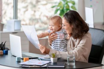Working mother with her baby in office�