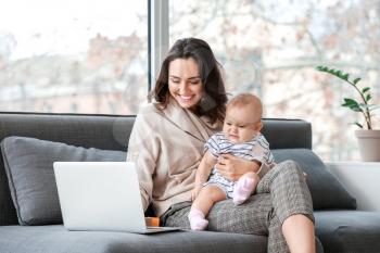 Working mother with her baby in office�