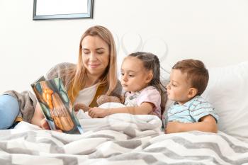 Nanny reading bedtime story for cute little children�