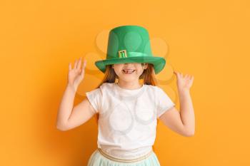Funny little girl on color background. St. Patrick's Day celebration�