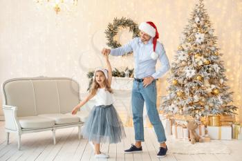 Happy father with little daughter dancing on Christmas eve at home�