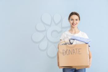 Volunteer with donations for poor people on color background�