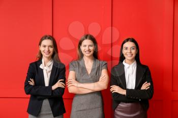 Beautiful young businesswomen on color background�