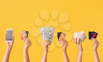 Female hands with money, credit cards, piggy bank and mobile phone on color background. Concept of online banking�