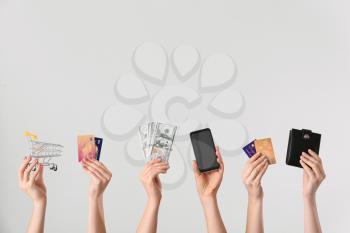 Female hands with money, credit cards, mobile phone, wallet and shopping cart on light background. Concept of online banking�