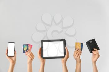 Female hands with mobile phone, credit cards, wallet and tablet computer on light background. Concept of online banking�