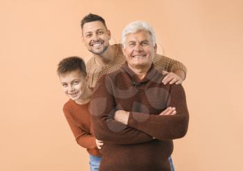 Man with his father and son on color background�