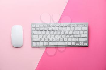 Computer keyboard and mouse on pink background�