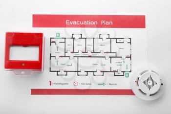 Evacuation plan, smoke detector and manual call point on white background�