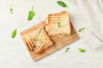 Board with tasty sandwiches on table�