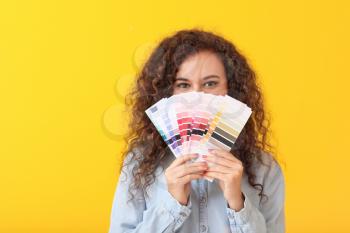 African-American woman with color palettes on yellow background�