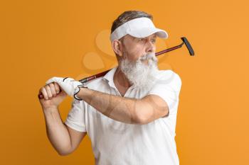 Sporty elderly golf player on color background�