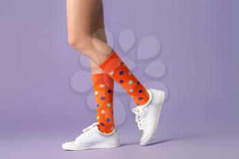 Legs of young woman in socks and shoes on color background�