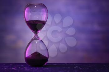 Hourglass on dark color background. Time management concept�