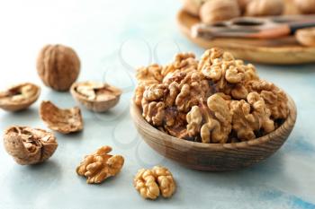 Bowl with tasty walnuts on table�