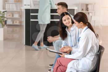 Female doctor with patient working in hall of clinic�