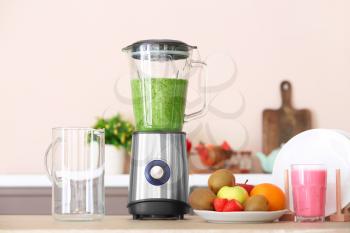 Modern blender and ingredients for healthy smoothie on kitchen table�