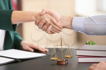 Female judge and client shaking hands in office, closeup�