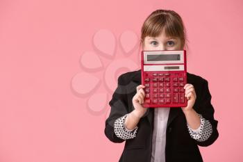 Little girl with calculator on color background�