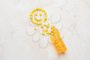 Bottle and face made of pills on grey background�