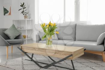 Interior of modern room with bouquet of spring flowers on table�