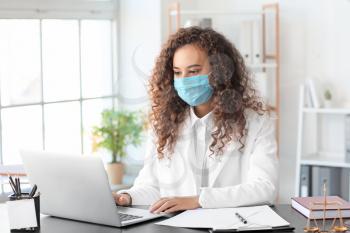 Female lawyer in protective mask working in office�