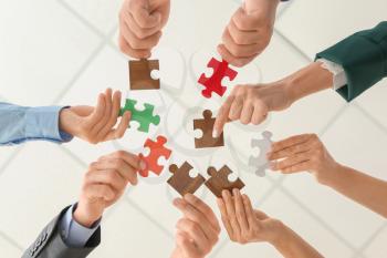 Business team with pieces of puzzle in office, bottom view�
