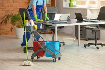 Male janitor cleaning in office�