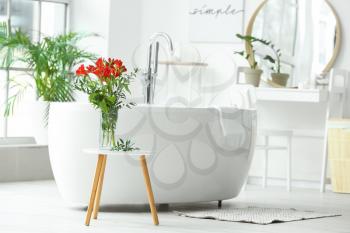 Stylish vase with floral decor in interior of bathroom�