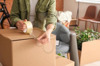 Woman packing moving box at home�