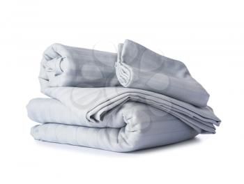 Stack of clean bed sheets on white background�