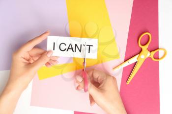 Woman with scissors turning phrase I CAN'T to I CAN on color background�