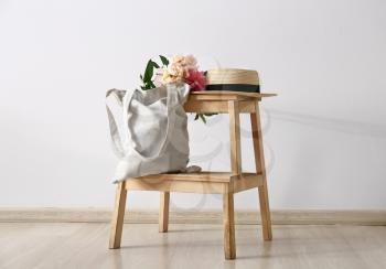 Eco bag with peony flowers and hat on step ladder�