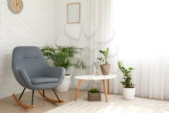 Interior of room with stylish armchair and houseplants�