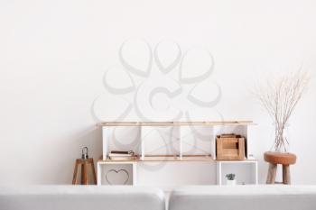 Stylish stand with decor near light wall in room�