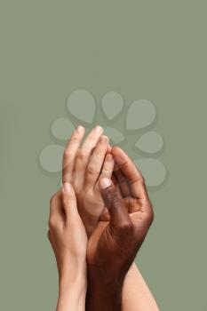 Hands of Caucasian woman and African-American man on color background. Racism concept�