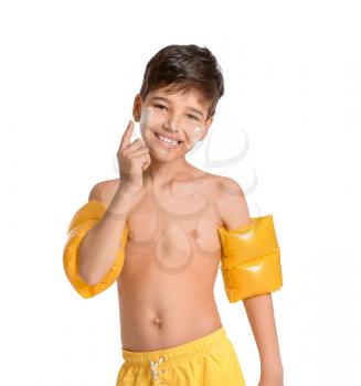 Little boy with sun protection cream on his face against white background�