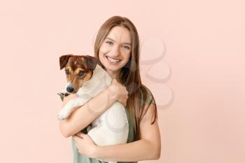 Young woman with cute dog on color background�