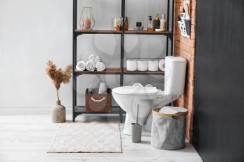 Stylish shelf and toilet bowl in interior of modern bathroom�